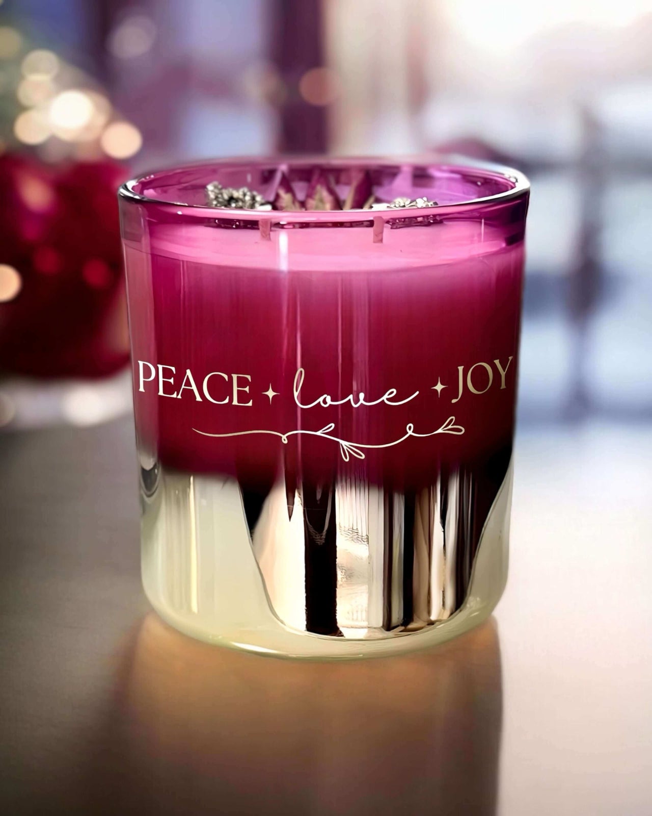 gold and red ombré Christmas candle, elegantly accented with gold writing that reads "Peace, Love, Joy." Infused with Pyrite.