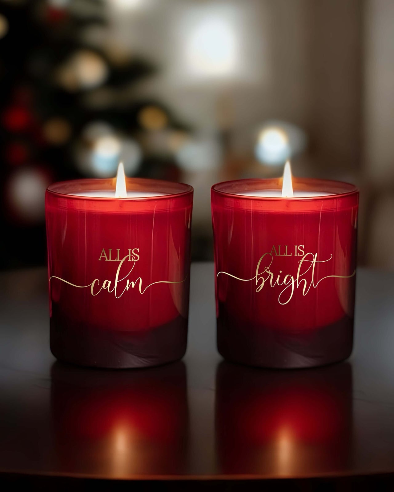 Two festive red candles burning brightly, written on the front of each candle is “All is calm