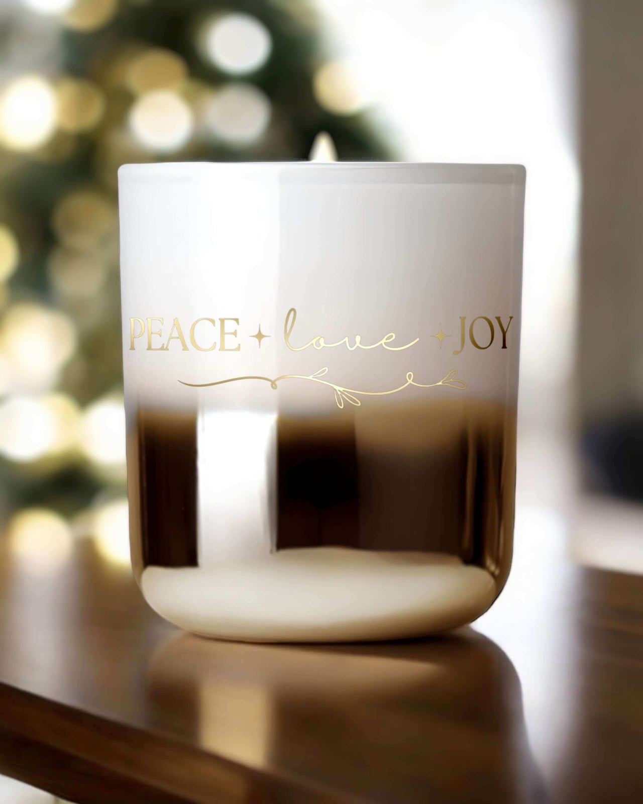 gold and white ombré Christmas candle, elegantly accented with gold writing that reads "Peace, Love, Joy." Infused with Pyrite.